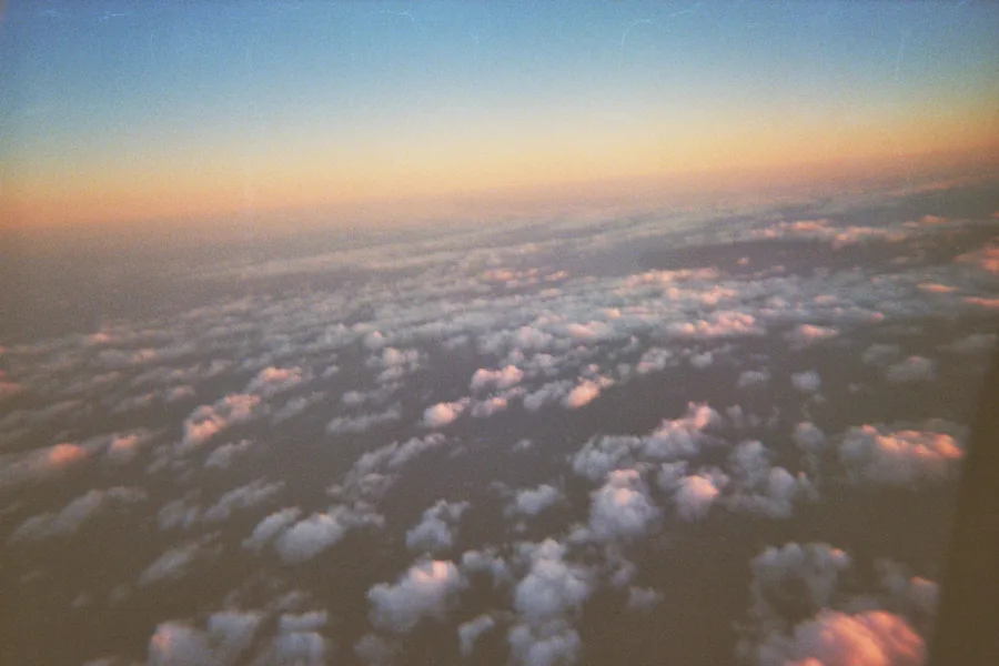 Nubes al atardecer desde la ventanilla de un avión, foto analógica de cámara desechable